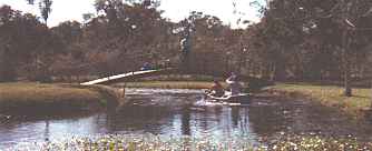 <Boat in water, bridge to island on left.>